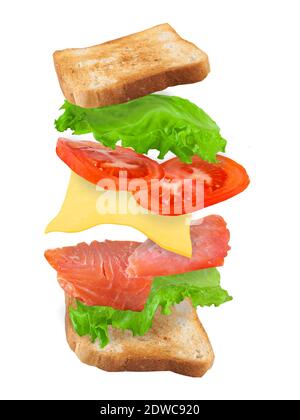 Flying sandwich with salmon, cheese and tomatoes isolated on a white background. Fast food concept. Vertical. Stock Photo