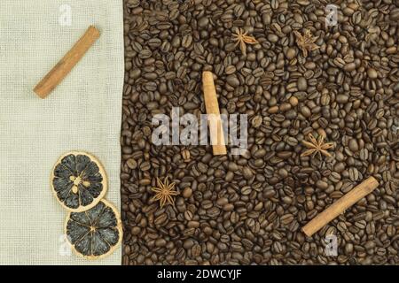 Coffee beans and nuts with cinnamon as a background. Coffee beans and anise scattered on a table with hazelnuts and cinnamon as wallpaper or backgroun Stock Photo