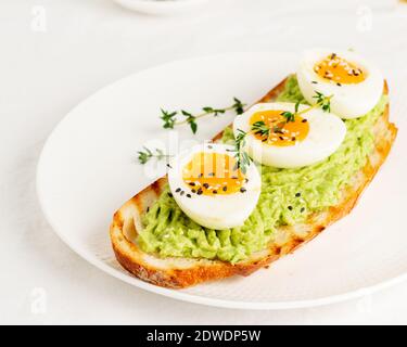 Avocado toast with toasted bread soft-boiled eggs with herbs Stock Photo