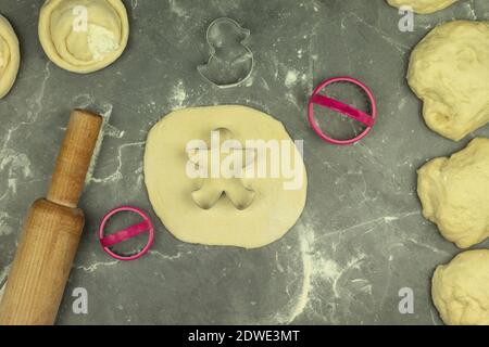 Fresh baked dough for the holiday season. A baker makes human-shaped baked goods in metal tins. Baking is made by hand at home Stock Photo