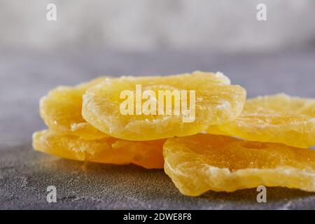 Yellow candied pineapple rings on a gray concrete background. Color trend 2021 Stock Photo