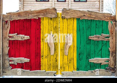 Close-up of the national flag of Guinea on a wooden gate at the entrance to the closed territory. The concept of storage of goods, entry to a closed a Stock Photo