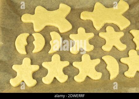 The Christmas gingerbread cookies are laid out on a baking sheet and ready to bake in the oven. Christmas gingerbread dough on a roasting pan for baki Stock Photo