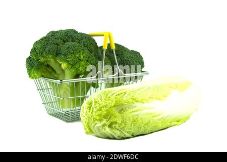 Broccoli cabbage on a white background with space for text. Metal shopping trolley and fresh broccoli. Broccoli inflorescence in a tiny cart on a whit Stock Photo