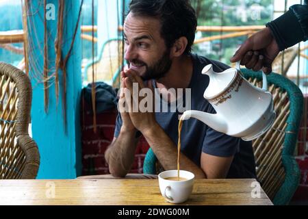 A young caucasian man showing gratitude for the tea Stock Photo