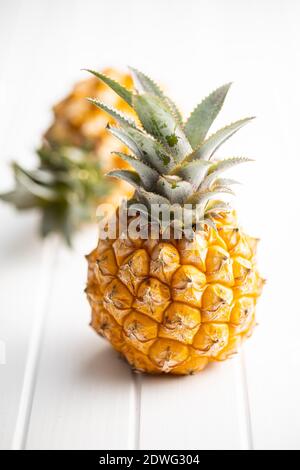 Ripe baby pineapple. Mini pineapple on white table. Stock Photo