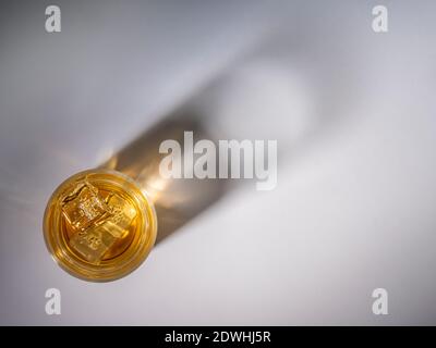 Whiskey in glass seen from above with shadow of glass on background. Stock Photo