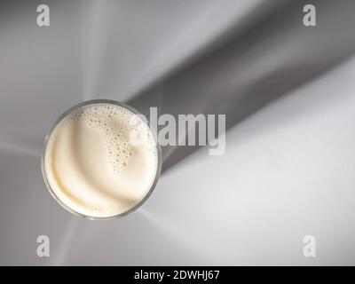 Glass of milk seen from above with shadow of glass on background. Stock Photo