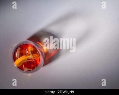Negroni cocktail drink in glass seen from above with shadow of glass on background. Stock Photo