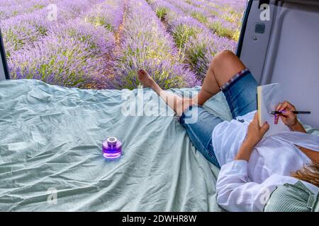 Lavender field with woman drawing on a camper Stock Photo