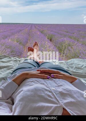 Lavender field with woman lying in a camper Stock Photo