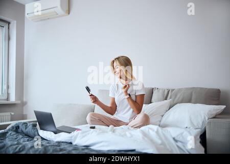 Good looking pretty lady relaxing at the weekend while watching something on laptop at home Stock Photo