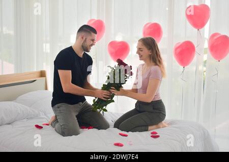 Love Couple giving Rose flower in bedroom happiness in love Valentine's day concept Stock Photo