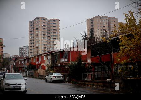 Typical contrast of an Istanbul street scene of small, cosy detached houses in the foreground and large residential silos, housing estates in the back Stock Photo