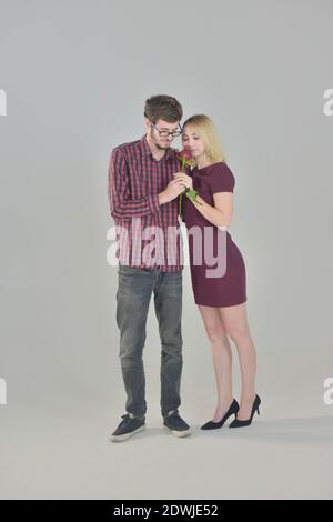 Young Couple giving Rose flower on white background Stock Photo