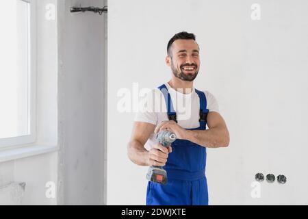 A foreman holds a drill in his hand and looks at the camera Stock Photo