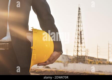 Close up project manager holding helmet hard hat construction building background Stock Photo