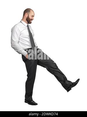 businessman isolated on white hands in pockets and action of kicking Stock Photo