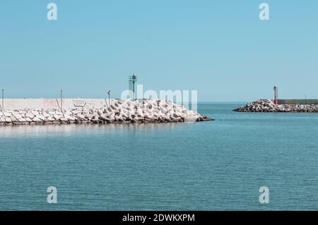 A red and a green lighthouse on the jetty of Pesaro harbour with tetrapod breakwaters (Marche, Italy, Europe) Stock Photo