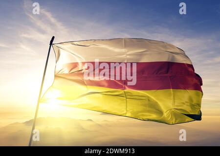 North Ossetia Republic of Russia flag waving on the top sunrise mist fog Stock Photo