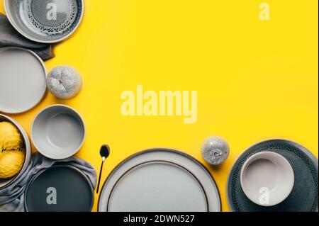 Gray empty ceramic plates on yellow Stock Photo