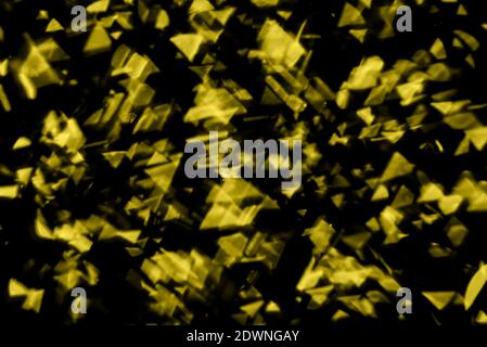 Blurred yellow sparkles on the black background. Trendy color. Demonstrating Color 2021. Stock Photo