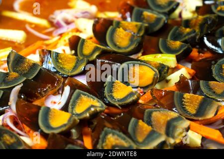 Street food market in Asia. A close-up, traditional dish of sliced pickled chicken eggs. Stock Photo