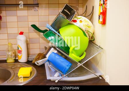 POZNAN, POLAND - Mar 05, 2016: Pile of cleaned dishes from different brands on a drying rack in a kitchen Stock Photo