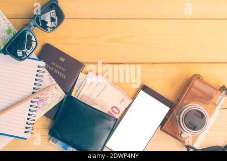 Closeup top view of the equipment needed for travel and tourism on wooden background. Stock Photo