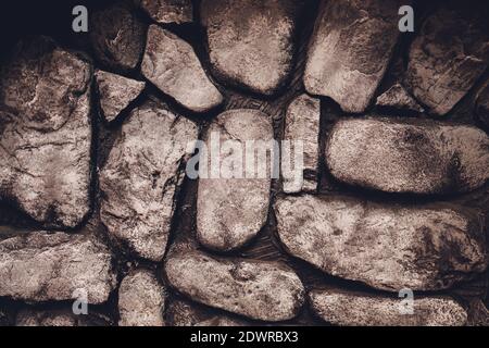 An abstract pattern created from the exterior wall of a fireplace made of rounded rocks from an old river bed Stock Photo