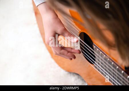 Close up of hand playing acoustic guitar. Practicing classic musical instrument. Home school education Stock Photo
