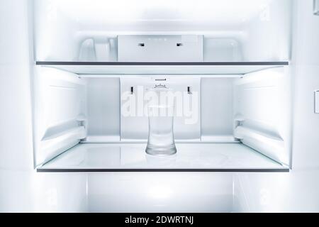 Cold glass of water in clean refridgerator Stock Photo