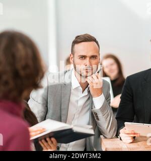 close up. brooding young entrepreneur sitting at office Desk. Stock Photo