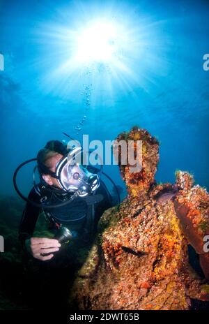 Scuba diver swimming by the submerged Nymphaeum of Emperor Claudius. Underwater ancient Roman ruins. Baia (Baiae), Campi Flegrei (Phlegraean Fields), Stock Photo