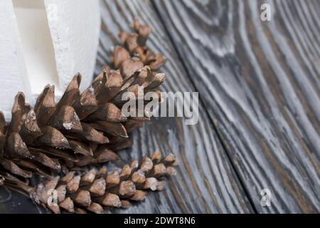 Larch cones. On black pine boards. Nearby is a white wooden box. Stock Photo
