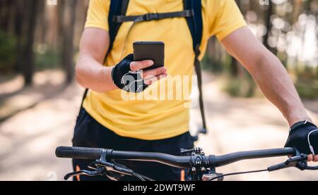 Man using smartphone for navigation during bicycle ride Stock Photo