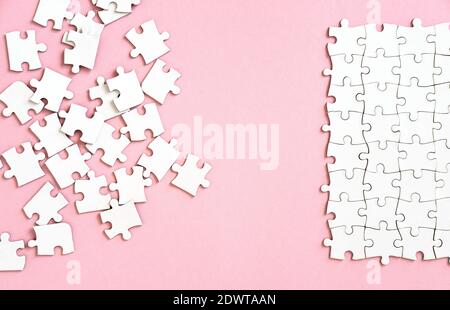 white puzzle pieces on pink background Stock Photo