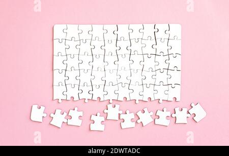 Unfinished white jigsaw puzzle, top view Stock Photo