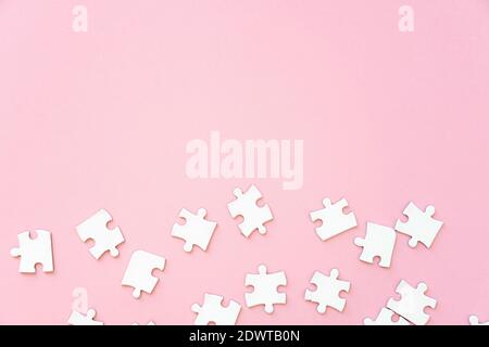 White jigsaw puzzle pieces on pink, top view copy cpace Stock Photo