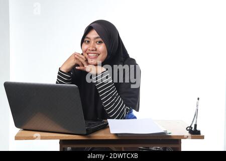 portrait of Asian woman wearing casual clothes working in an office. a veiled woman with a happy expression working at a computer. the concept of a su Stock Photo