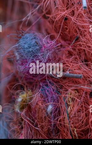 fishing nets washed up by the sea and a piece of rope entangled all together it is very difficult to catch Stock Photo