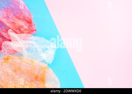 Crumpled plastic bags on blue and pink background with copy spase. Garbage sorting and conservation ecology concept. Flatlay composition. Stock Photo