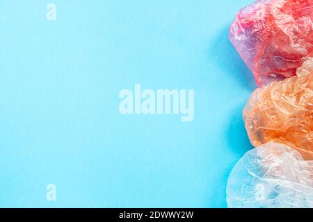 Flatlay composition wrinkled colorful plastic bags on a blue background with copy spase for text. Save the ecology concept. Stock Photo