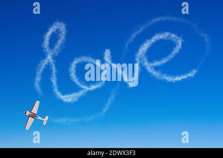 Love figurative inscription from a white smoke trail airplane Stock Photo