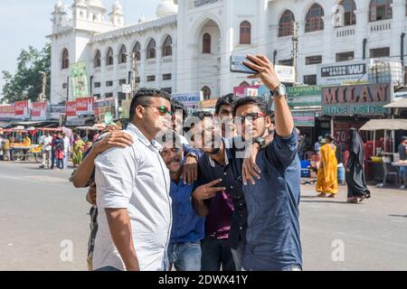 A group of Indian Young men self taking selfies in the Charminar street of Hyderabad, India Stock Photo