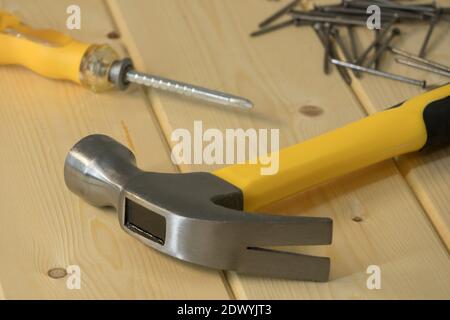 Assorted work tools on wood. Hand tools on a wooden background, hammer with nails and screwdriver. Home renovation, construction. Hand tools and equip Stock Photo