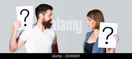 Confused couples with question marks. Conflict between two people. Pensive man and a thoughtful woman, conflict. Portrait of couple holding paper Stock Photo