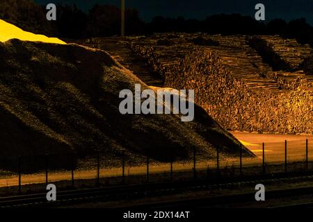 A large pile of logs and wood chips, a sustainable source of renewable ...
