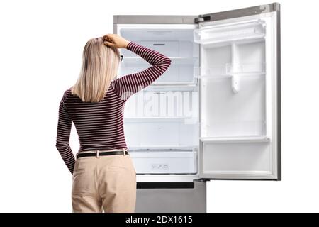 Rear shot of a woman holding her head and looking at an empty fridge isolated on white background Stock Photo