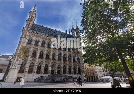 Leuven, Belgium, August 2019. The town hall square is dominated by the eye-catching palace decorated with numerous statues and colored flags. Beautifu Stock Photo